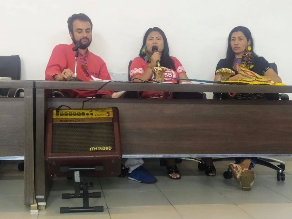 O professor Paulo está sentado à mesa ao lado de duas pesquisadoras em um evento chamado Mesa Políticas Linguísticas no Leste Brasileiro. foto do acervo pessoal prof. Paulo de Tássio Borges da Silva